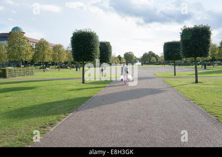 Femme marche dans un parc au centre de Letchworth Garden City Hertfordshire UK Banque D'Images