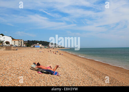 Deux femmes en train de bronzer sur une plage de galets à Sandgate Esplande Folkestone. Banque D'Images