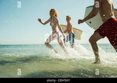 Trois adolescents avec des planches de bord à la mer Banque D'Images