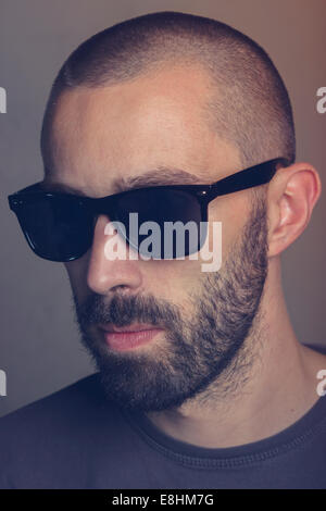Portrait d'un jeune homme à barbe portant des lunettes de soleil rétro Banque D'Images