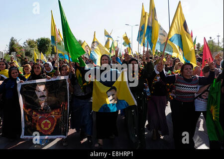 Les femmes kurdes holding flags avec la figure d'Abdullah Ocalan, membre fondateur de l'organisation militante du Parti des Travailleurs du Kurdistan ou PKK lors d'un rassemblement à l'appui de Kurdes syriens souffrant d'ISIS les attaques dans la ville syrienne de Kobane dans la ville d'Erbil Arbil Irbil, aussi orthographié ou la capitale de la région du Kurdistan dans le nord de l'Iraq. Banque D'Images