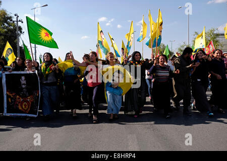 Les femmes kurdes holding flags avec la figure d'Abdullah Ocalan, membre fondateur de l'organisation militante du Parti des Travailleurs du Kurdistan ou PKK lors d'un rassemblement à l'appui de Kurdes syriens souffrant d'ISIS les attaques dans la ville syrienne de Kobane dans la ville d'Erbil Arbil Irbil, aussi orthographié ou la capitale de la région du Kurdistan dans le nord de l'Iraq. Banque D'Images