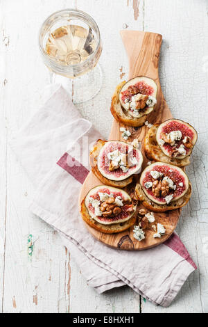 Bruschettas aux figues, roquefort et noix sur du pain croûté grillé sur fond de bois Banque D'Images