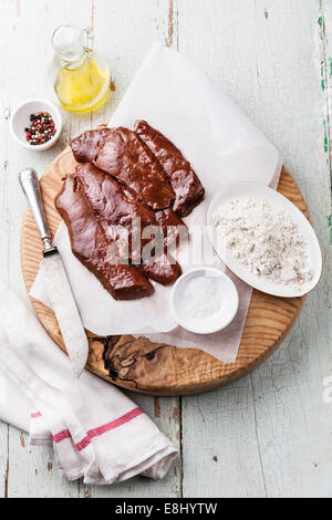 Foie cru avec des ingrédients sur le tableau texturé en bois Banque D'Images