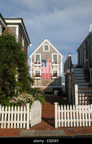 Une porte s'ouvre vers une jolie maison avec les boîtes à fleurs sur windows, drapé d'un grand drapeau américain. Provincetown, Cape Cod Banque D'Images