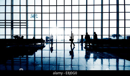 Silhouettes of Multi-Ethnic groupe de gens d'affaires en attente dans un terminal de l'aéroport Banque D'Images