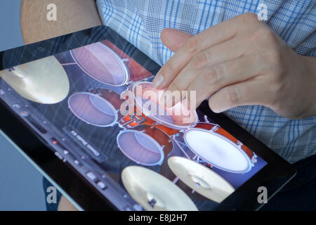 Tambov, Fédération de Russie - le 20 janvier 2013 : la main de femme à jouer de la batterie avec l'application GarageBand sur un Apple iPad. Banque D'Images