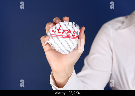 Boule de papier froissé avec mots stress dans la main des femmes. Banque D'Images