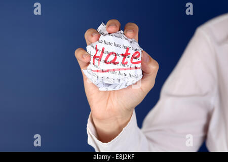 Boule de papier froissé avec des mots "la haine" dans la main des femmes. Banque D'Images