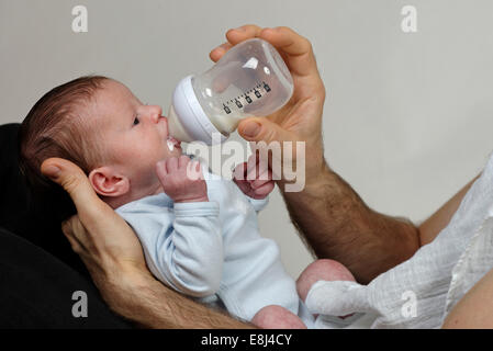 Trois semaines garçon bébé est nourri avec la bouteille par son père Banque D'Images