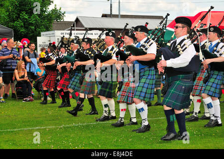 Cornemuses défilent à l'unisson sur le terrain de sport au Highland Games, Dufftown, Moray, Highlands, Ecosse, Royaume-Uni Banque D'Images