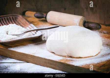 La cuisson du pain. Pâte sur table en bois avec de la farine et de l'axe de roulement-vintage Banque D'Images