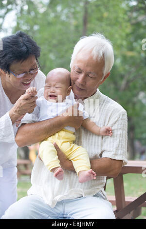 Les grands-parents asiatiques réconfortant crying baby grandson at outdoor Banque D'Images