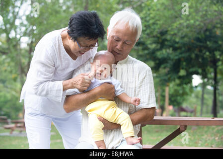 Les grands-parents asiatiques réconfortant crying baby grandson at outdoor Banque D'Images