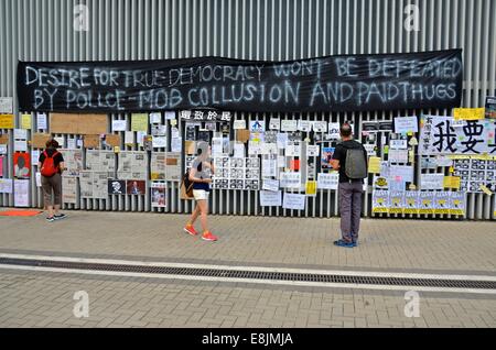 Hong Kong. 9 octobre, 2014. Les gens de la lecture des messages qui ont été affichés sur les murs des édifices gouvernementaux sur le 12e jour de la protestation pro-démocratie connu comme 'Central' occupent, qui a bloqué la circulation sur les routes principales dans le centre-ville de Hong Kong. L'ambiance continue d'être généralement pacifique, bien que les résidents d'inconvénients sont de plus en plus en colère contre le bloqué les rues. Credit : Stefan Irvine/Alamy Live News Banque D'Images