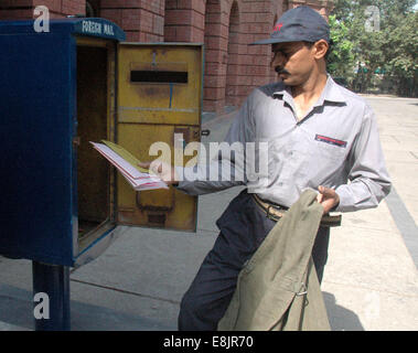 Lahore. 9 octobre, 2014. Un facteur pakistanais recueille des lettres d'une boîte aux lettres sur la Journée mondiale de la poste dans l'est de Lahore au Pakistan, le 9 octobre 2014. Journée mondiale de la Poste est célébrée chaque année le 9 octobre, l'anniversaire de la création de l'Union postale universelle (UPU) en 1874 dans la capitale suisse, Berne. Il a été déclaré Journée mondiale de la poste par le Congrès de l'UPU qui s'est tenue à Tokyo, au Japon, en 1969. © Sajjad/Xinhua/Alamy Live News Banque D'Images