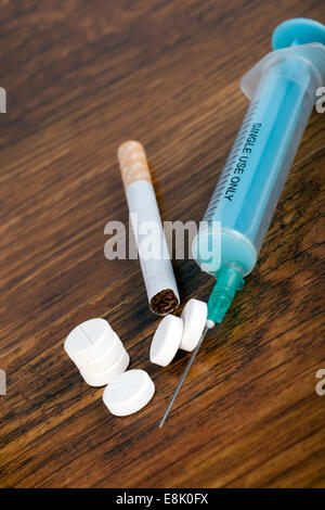Concept de la toxicomanie avec seringue, cigarette et comprimés Banque D'Images