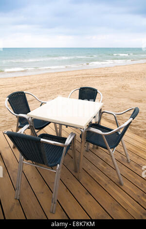 Espace ouvert côté mer bar intérieur avec plancher en bois et métal Fauteuils on sandy beach Banque D'Images