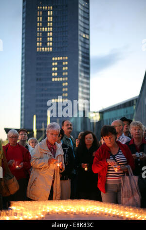 Leipzig, Allemagne. 9 octobre, 2014. Les visiteurs de la Fête des Lumières place bougies en Augustenplatz square à l'occasion du 25e anniversaire de la révolution pacifique à Leipzig, Allemagne, 09 octobre 2014. La ville de Leipzig commémore l'anniversaire avec des invités de haut rang et un festival des lumières. Le 9 octobre 1989 environ 70 000 personnes se sont rassemblées à Leipzig sous la bannière de "Nous sommes le peuple". Dpa : Crédit photo alliance/Alamy Live News Banque D'Images