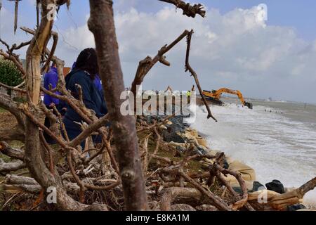 Pagham, West Sussex, UK. 9 octobre, 2014. Les tempêtes d'éroder Pagham Beach front de mer mettant en danger les maisons.Pour la deuxième journée les tempêtes ont frappé la plage de galets de quitter la mer à quelques mètres de maisons résidentielles. Traitants de travailler furieusement contre le ressort des grandes marées et les vents sur la côte. La prochaine crise est la marée haute à minuit. Crédit : Gary Blake/Alamy Live News Banque D'Images