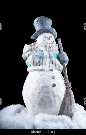 Un bonhomme de neige décoratif dans l'obscurité, le froid à l'extérieur pendant la saison de vacances. Banque D'Images