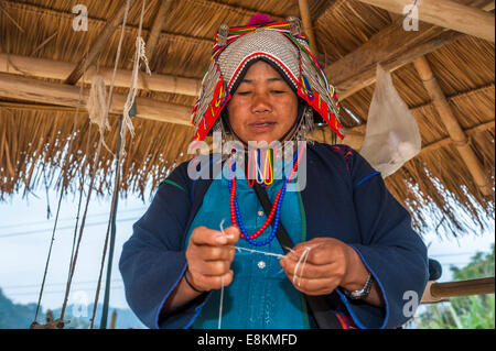 Habillé traditionnellement femme de la tribu Akha, hill, minorité ethnique, le tissage de fils, province de Chiang Rai Banque D'Images