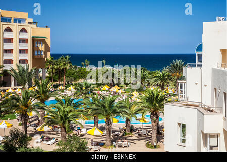 La piscine d'un hôtel 5 étoiles près de Port el Kantoui dans Tunsia avec la mer au-delà. Banque D'Images