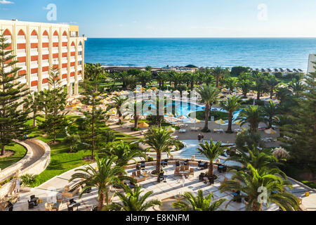 Vue sur la piscine d'un hôtel 5 étoiles près de Port el Kantoui dans Tunsia avec la Méditerranée au-delà. Banque D'Images