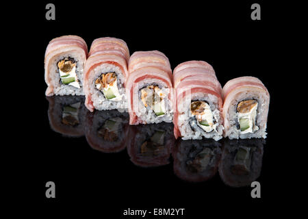 Ensemble de rouleaux de sushi enrobé de bacon sur fond noir Banque D'Images