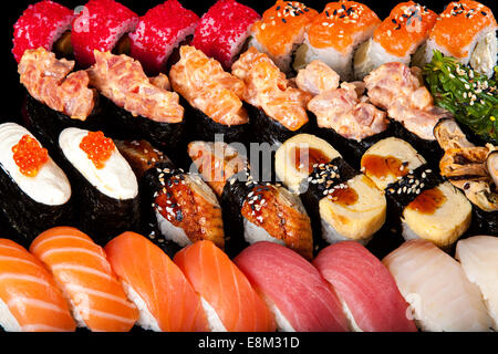 Ensemble de rouleaux de sushi et sashimi sur fond noir Banque D'Images