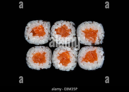 Ensemble de rouleaux de sushi avec du saumon sur fond noir Banque D'Images