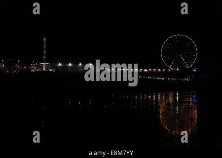 Nuit vue sur la plage, avec des réflexions de roue, au sud en direction de Central Pier 'big wheel' et 'Sky Flyer', illuminations de Blackpool, Royaume-Uni Banque D'Images