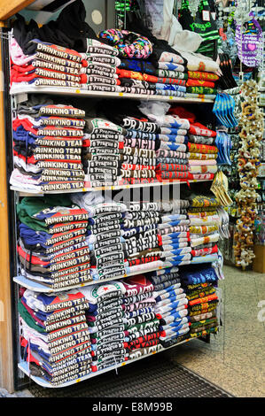 Une grande sélection de T-shirts colorés sur les étagères dans un magasin à Prague, République tchèque. Banque D'Images
