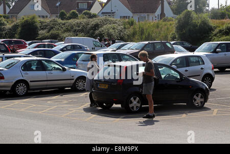 Père et fille en voiture dans Parking près de Avon Beach Mudeford Dorset Angleterre Banque D'Images