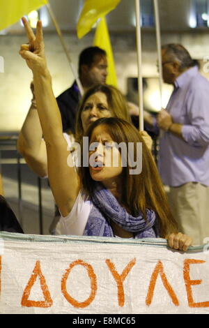 Athènes, Grèce. 10 octobre 2014. Un manifestant soulève son bras dans un signe de victoire à l'extérieur du Parlement grec. Les manifestants de plusieurs groupes anti-gouvernementaux ont protesté devant le Parlement grec le soir du vote de confiance dans le gouvernement grec qui a eu lieu à l'intérieur. La protestation a été principalement dirigée contre les mesures d'austérité introduites par le gouvernement grec dans les dernières années. Crédit : Michael Debets/Alamy Live News Banque D'Images