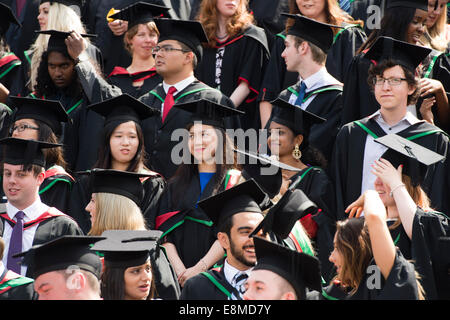 Une foule d'ethnies mixtes étrangers européens et asiatiques, les étudiants du collège, hommes et femmes dans leurs robes traditionnelles et les conseils de mortier après avoir obtenu le jour de la remise des diplômes de l'Université d'Aberystwyth, Pays de Galles, UK 2014 Banque D'Images