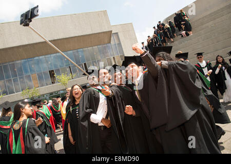 Un groupe d'étudiants d'outre-mer dans leurs robes traditionnelles et les conseils de mortier en tenant une cérémonie de remise des diplômes selfies Royaume-uni Aberystwyth Banque D'Images