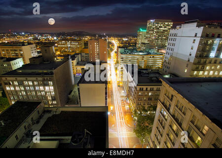 Pleine lune s'élève au-dessus de l'Oregon Portland Cityscape avec une longue exposition Feu sentiers dans le sud-ouest de Washington Street Banque D'Images