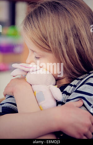 Jeune fille de câliner un doudou consolateur. Banque D'Images