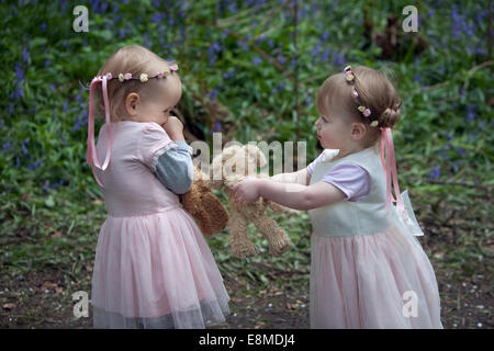 Deux jeunes enfants à l'extérieur l'apprentissage de la notion de partage des jouets. Banque D'Images