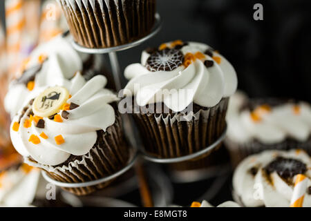 Halloween au chocolat cupcakes avec glaçage blanc buttercreme et de copeaux de chocolat sur le dessus. Banque D'Images