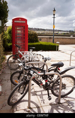 Royaume-uni, Angleterre, Devon Barnstaple, Le Carré, vélos verrouillé pour poster au bord de la rivière Taw phone box Banque D'Images