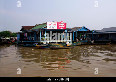 Lac Tonle Sap, épicerie flottante, femme pousse son petit bateau inachevé avec une perche. Banque D'Images