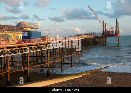 Hastings East Sussex UK, 11 octobre 2014. Avec la grue et barge coûtant £13 000 par jour pour accéder à la fin de la jetée, on poursuit le démantèlement la twisted metal squelette de l'ancienne salle de bal, la jetée a été détruit par un incendie en octobre 2010 et est en cours de rénovation pour un coût total de 14 millions de livres sterling. Banque D'Images