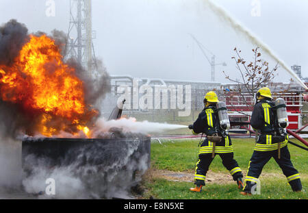 Deux pompiers lutter contre une grande flamme feu. Banque D'Images