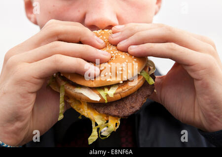 Un adolescent de manger un hamburger Big Mac de McDonald's. Banque D'Images