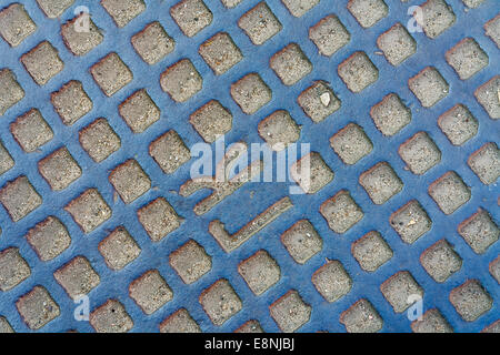 La texture composée d'une partie de l'écoutille alternant avec de petites pierres et de sable Banque D'Images