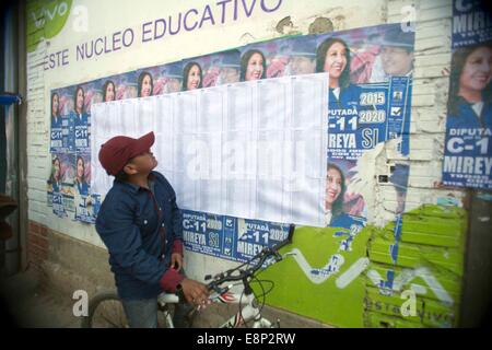 El Alto, en Bolivie. 12 octobre, 2014. Un garçon regarde une liste électorale dans une école de la ville de El Alto, en Bolivie, le 12 octobre, 2014. Des millions de Boliviens coffré leurs votes aux élections générales pour un nouveau président et de législateurs d'état le dimanche. Crédit : David de la Paz/Xinhua/Alamy Live News Banque D'Images