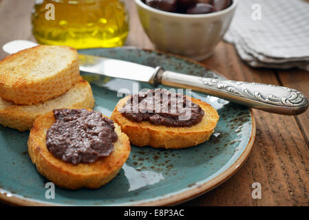 Du pain avec de la pate d'olive sur gros plan de la plaque. La cuisine grecque Banque D'Images