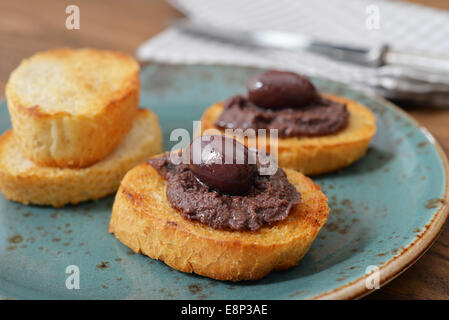 Du pain avec de la pate d'olive sur gros plan de la plaque. La cuisine grecque Banque D'Images